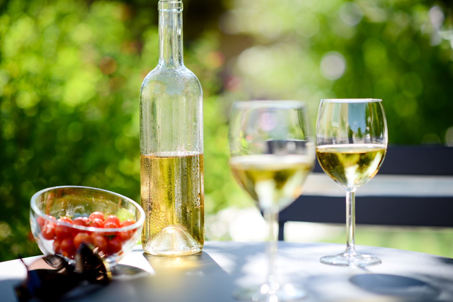 Weißwein im Glas bei Sonnenschein im Garten